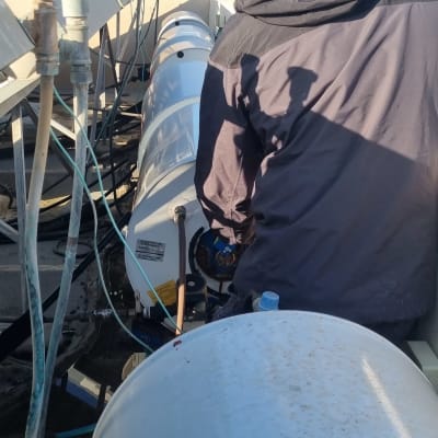 אדם עובד על דוד שמש על גג בניין