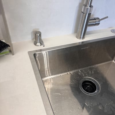 שיש לבן ליד כיור נירוסטה וברז מתכת