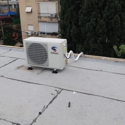 יחידת מיזוג אוויר על גג שטוח עם צינורות מחוברים