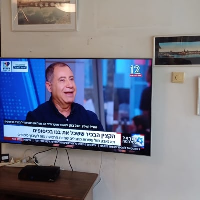 טלוויזיה תלויה על הקיר עם כבלים חשמליים