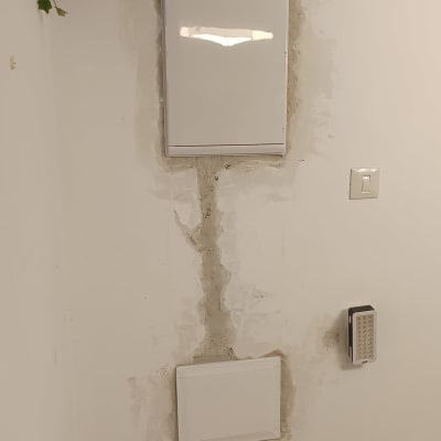 ארון חשמל מותקן על קיר עם תיקוני טיח