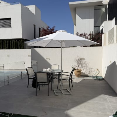 פינת ישיבה עם שמשייה בחצר בית מודרני