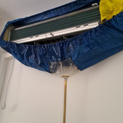 מזגן מכוסה ביריעת ניקוז כחולה עם צינור