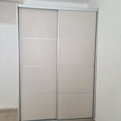 ארון הזזה עם דלתות לבנות בחדר ריק