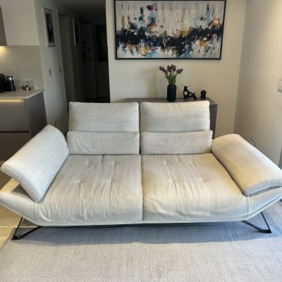 ספה בהירה בחדר מגורים עם שטיח