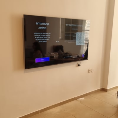 טלוויזיה מותקנת על הקיר עם כבלים חשופים