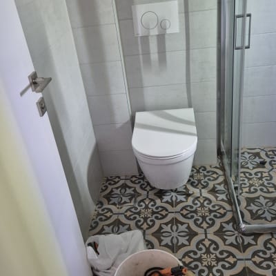 כלים וסל פלסטיק בחדר אמבטיה עם שירותים