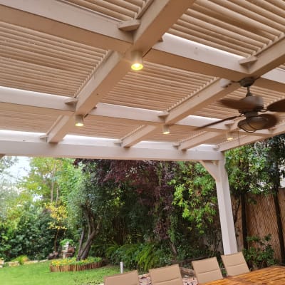 פרגולה מעץ עם מאוורר תקרה בגינה ירוקה