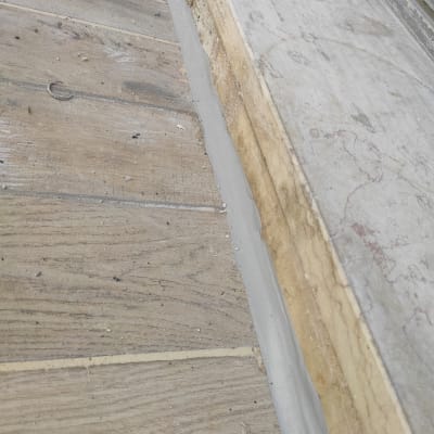 איטום בין רצפה לקיר עם חומר אפור