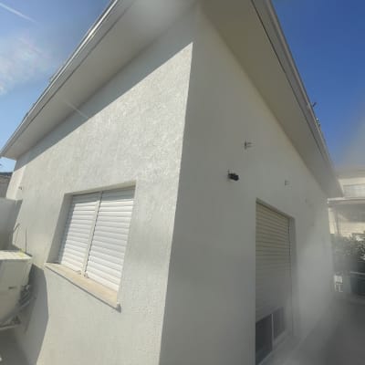 קיר חיצוני של מבנה עם חלונות ותריסים סגורים