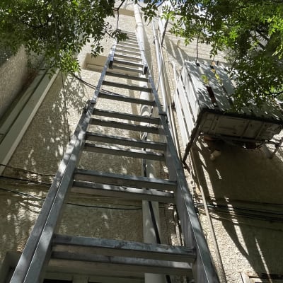סולם מתכת גבוה צמוד לקיר בניין