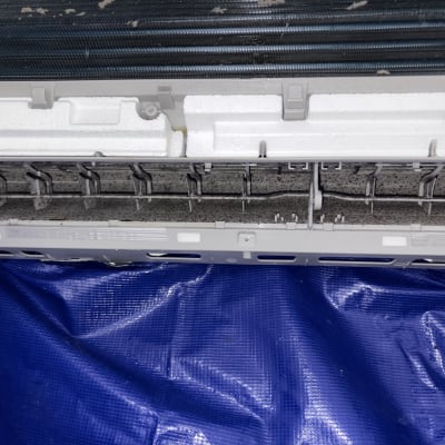 יחידת מיזוג אוויר פתוחה על יריעת פלסטיק כחולה