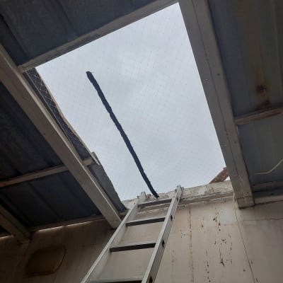 סולם מתכת מוביל לפתח ברשת תקרה