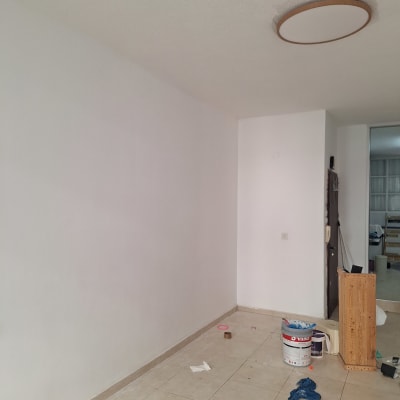 קיר צבוע עם דלי צבע וכלי עבודה על הרצפה