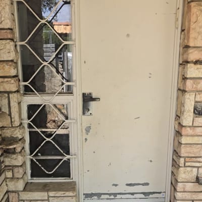 דלת מתכת עם צבע מתקלף וידית שחורה