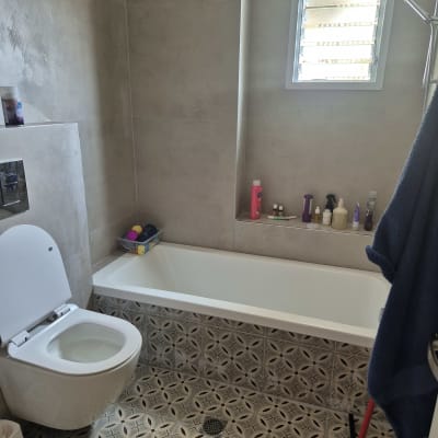 חדר אמבטיה עם אריחים מעוצבים ואמבטיה חדשה