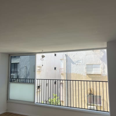 חלון גדול עם מסגרת מתכת ונוף עירוני