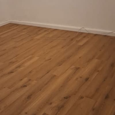 רצפת פרקט בחדר ריק עם קיר לבן