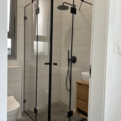 מקלחון זכוכית עם ראש מקלחת עגול ושחור