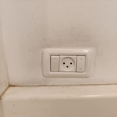 שקע חשמל עם כפתורי שליטה בקיר לבן