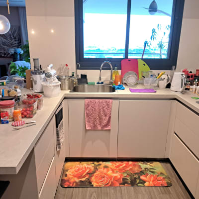 מטבח עם כלים על השיש, קרש חיתוך, קומקום חשמלי