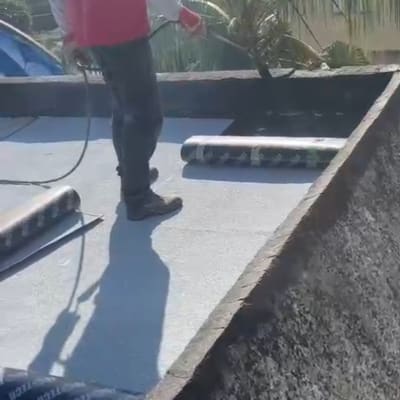 אדם עם צינור על גג עם יריעות איטום