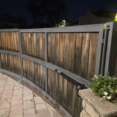 שער חשמלי מעץ ומתכת עם תאורה בלילה