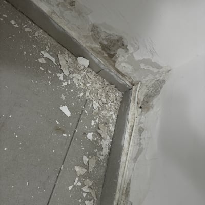 קיר עם טיח מתקלף ורצפה עם שברי טיח