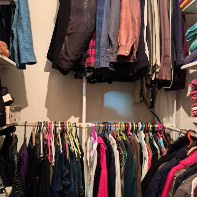 ארון בגדים מסודר עם בגדים תלויים על קולבים