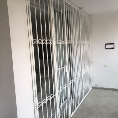 סורגים לבנים על חלון זכוכית במרפסת