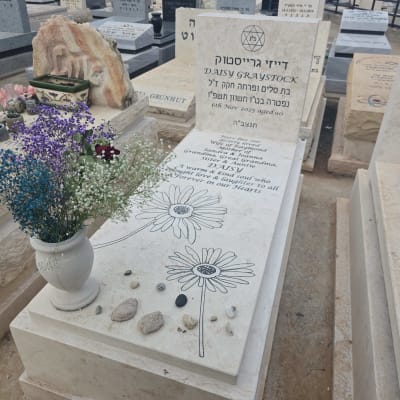 מצבות עם פרחים ואבנים קטנות בבית קברות