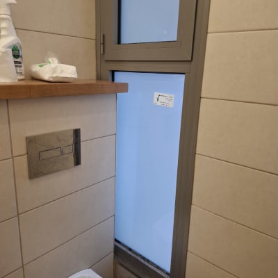 חלון זכוכית עם מסגרת מתכת בחדר אמבטיה