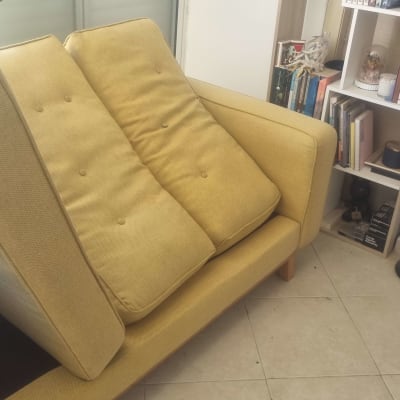 ספה צהובה עם כריות בסלון ביתי