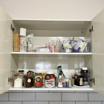 ארון מטבח פתוח עם מוצרי מזון מסודרים על מדפים