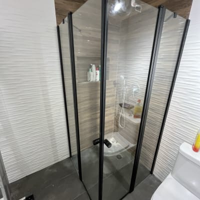 מקלחון זכוכית עם ראש מקלחת ומוצרי טיפוח