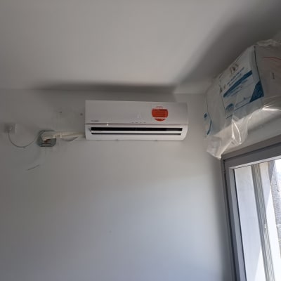 מזגן מותקן על קיר עם צינורות חשמל