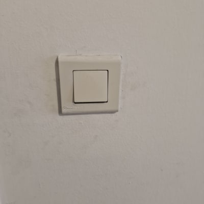 מתג חשמל לבן על קיר לבן