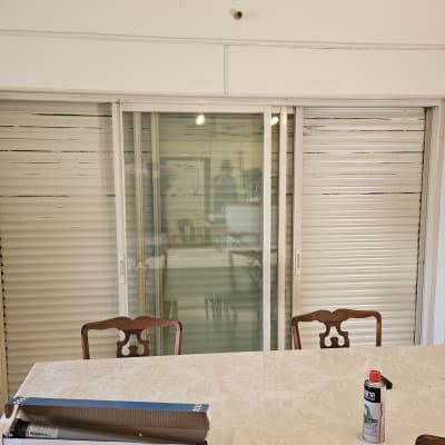 תריסים סגורים בחדר עם שולחן וכיסאות