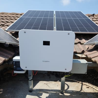 פאנלים סולאריים על גג עם ממיר חשמל