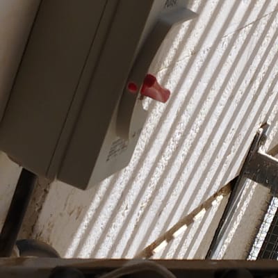 מתג חשמלי עם ידית אדומה על קיר