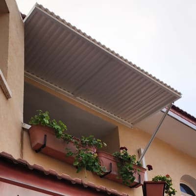 גגון אלומיניום מעל מרפסת עם עציצים