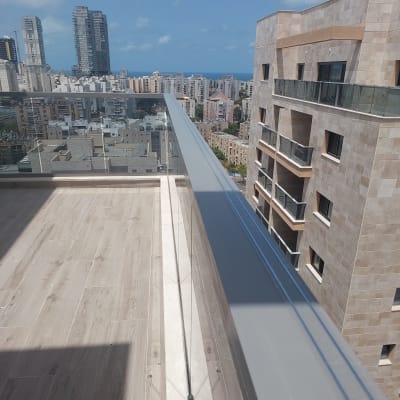 מרפסת עם מעקה זכוכית ונוף עירוני