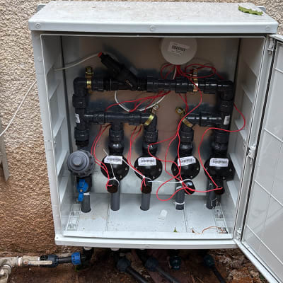 מערכת השקיה עם צינורות ושסתומים בגינה