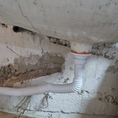 כיור עם צינור ניקוז גמיש מחובר לקיר