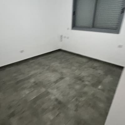 חדר ריק עם רצפה נקייה וחלון סגור