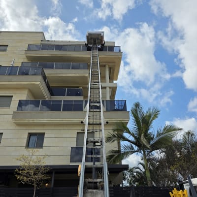 מנוף הרמה לבניין גבוה עם שמיים כחולים