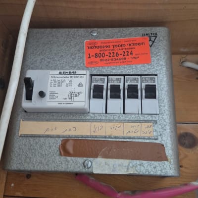 לוח חשמל עם מפסקים וכיתוב בעברית