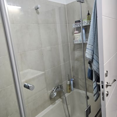 מקלחת עם דלת זכוכית ומגבת תלויה