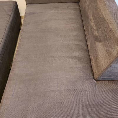 ספה אפורה עם כתמים קלים על המושב והמשענת