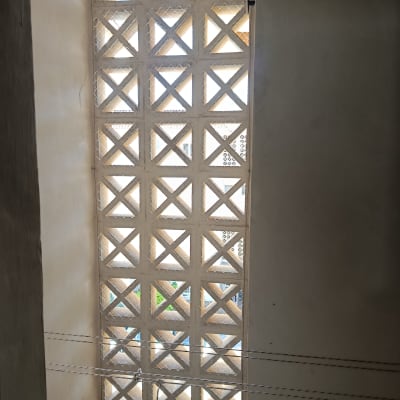 רשת יונים מותקנת על חלון עם סורגים